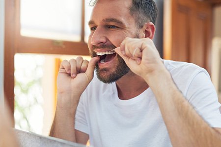 Man flossing his teeth