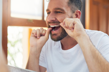 Man flossing his teeth