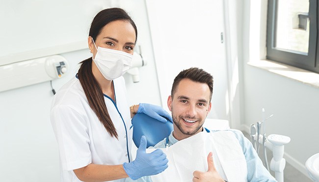 Dentist in Fort Worth giving a thumb’s up while treating a patient’s gum disease